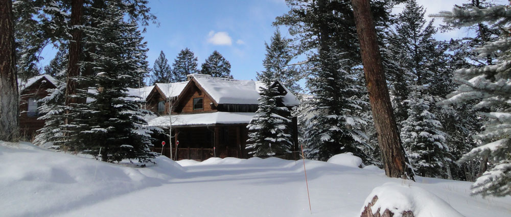 Snow-covered cabin in a winter forest.